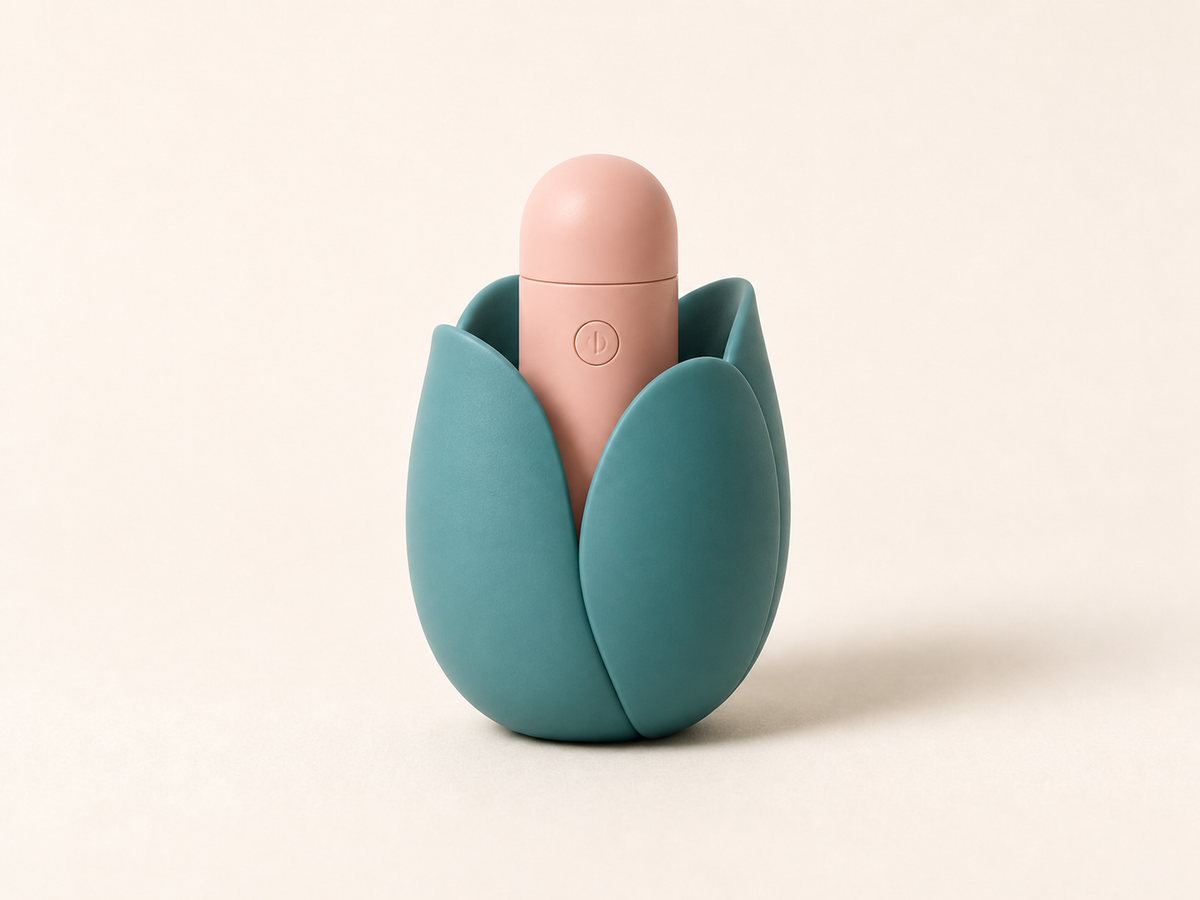 A compact peach toy nestled discreetly in a teal tulip-shaped holder on a cream background.